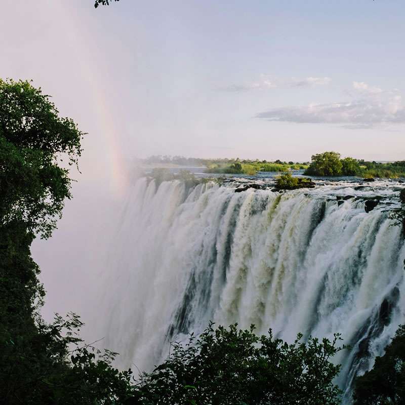 Victoria Falls from the Zambian side with a rainbow over the spray during African safari holiday tours